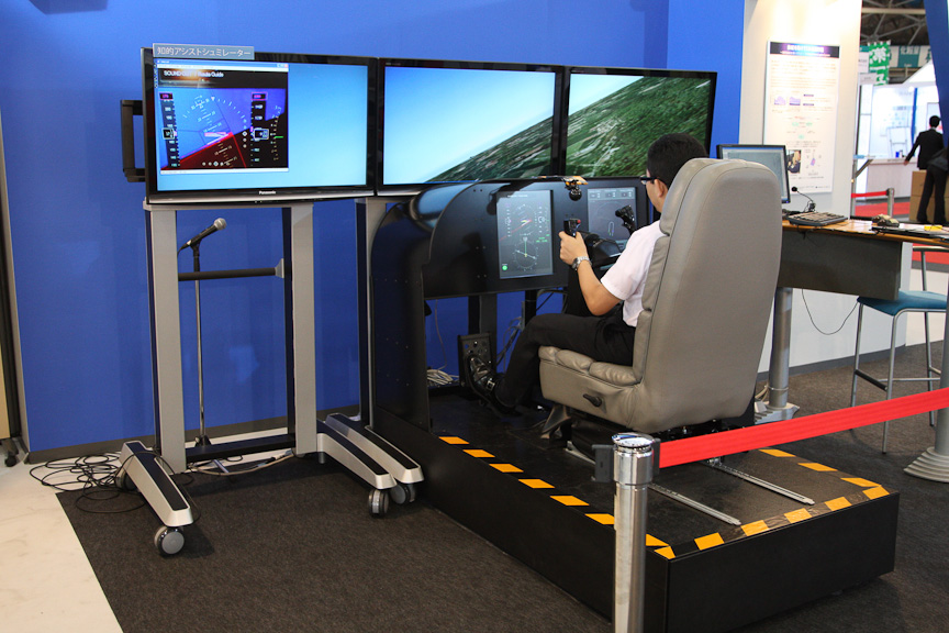 3面のディスプレイを用いたフライトシミュレーター。操縦桿の前にはMFD（マルチファンクションディスプレイ）も設置されている