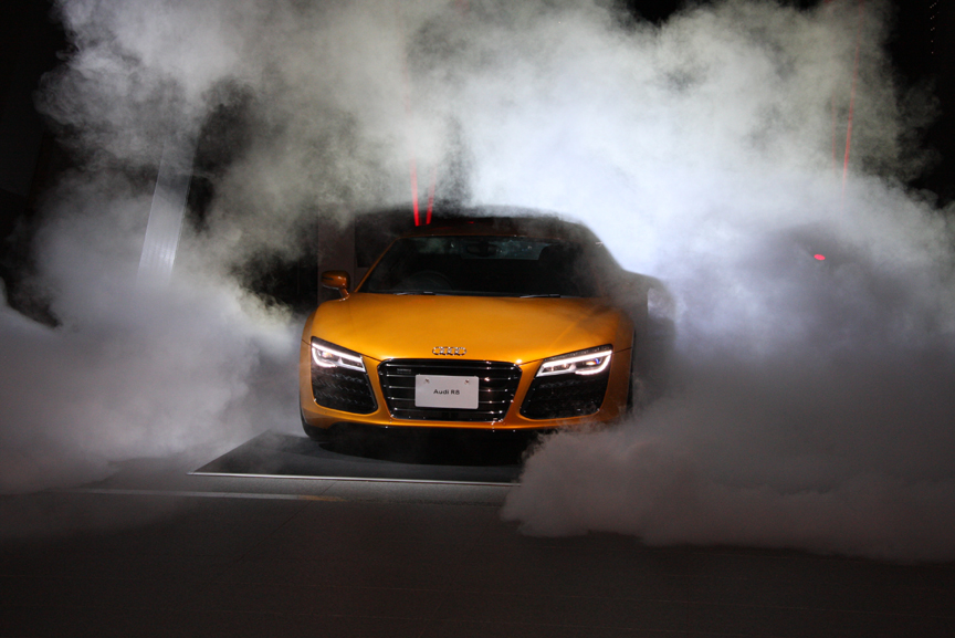 スモーク噴射の演出の向こう側から2013年モデルのR8が登場した