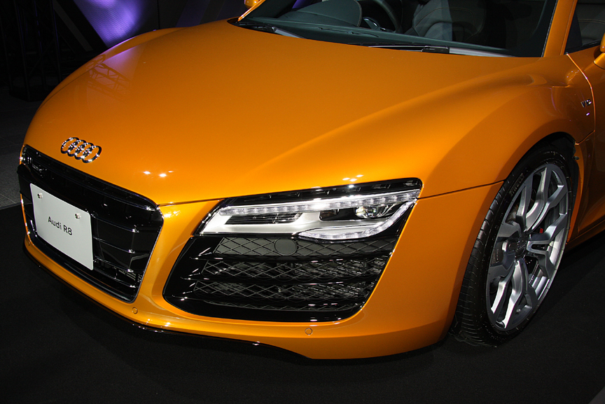 R8のデザインアイデンティティでもあるシングルフレームグリルとフルLEDヘッドライトの組み合わせ。従来は外側にロービーム、内側にハイビームを配置していたが、今モデルから最上段がロービーム、ポジショニングランプ＆ウインカーを挟んで下段がハイビームというレイアウトに変更された
