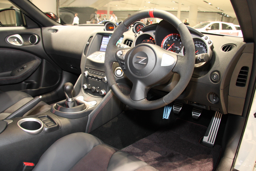 レッドセンターマーク入りのアルカンターラ巻3本スポークステアリングや本革巻シフトノブを備えるインテリア