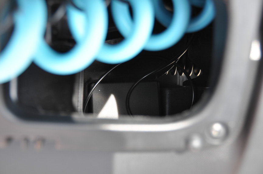 そのケーブルの奥に見える黒い箱がユビ電の車載器。クルマのIDなどをユビ電の充電ボックスとやり取りする