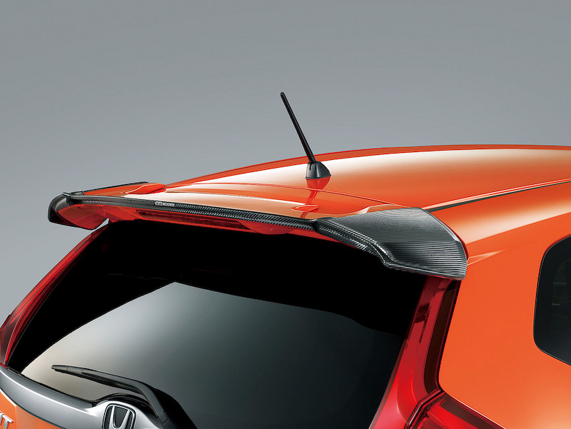 Sパッケージ、RSが装着する純正テールゲートスポイラーに被せて装着するドライカーボン製「カーボンアッパーウイング」（6万3000円）。UVカットクリアコート仕上げで、無限のロゴ入り