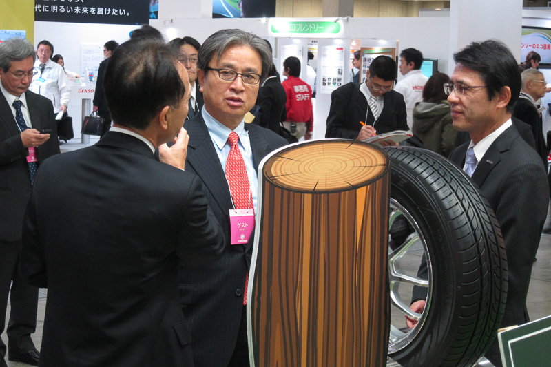 北川知克環境副大臣（中央）もエコプロダクツ展を視察。100％石油外天然資源タイヤ「エナセーブ 100」の説明を受ける。左は住友ゴム工業常務執行役員 研究開発本部長 兼 材料開発本部長 中瀬古広三郎氏、右は住友ゴム工業 常務執行役員 ダンロップタイヤ営業本部長 山本悟氏