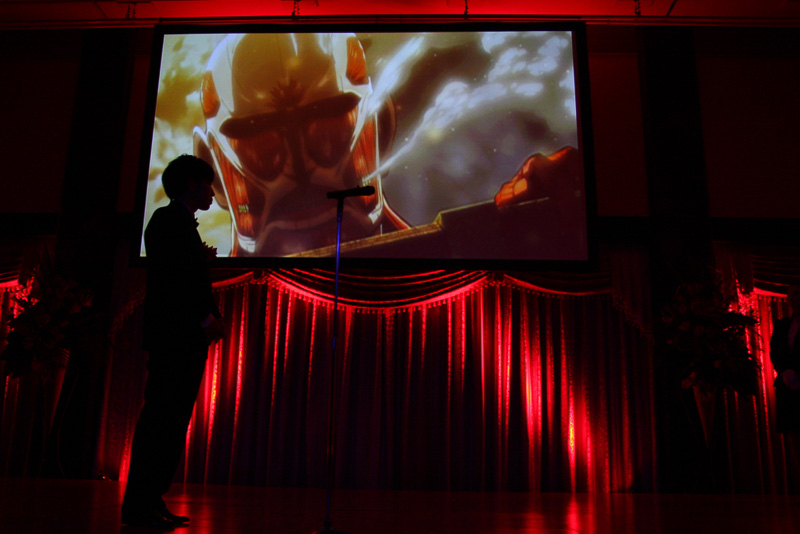 表彰シーンでは、進撃の巨人のアニメ映像が流れたあと、同作のゆるキャラ「巨人くん」が登場する演出も実施。歴史あるAMDアワードのフラッグを受け取り、この作品の幅広い展開をコミカルなアクションで表現している