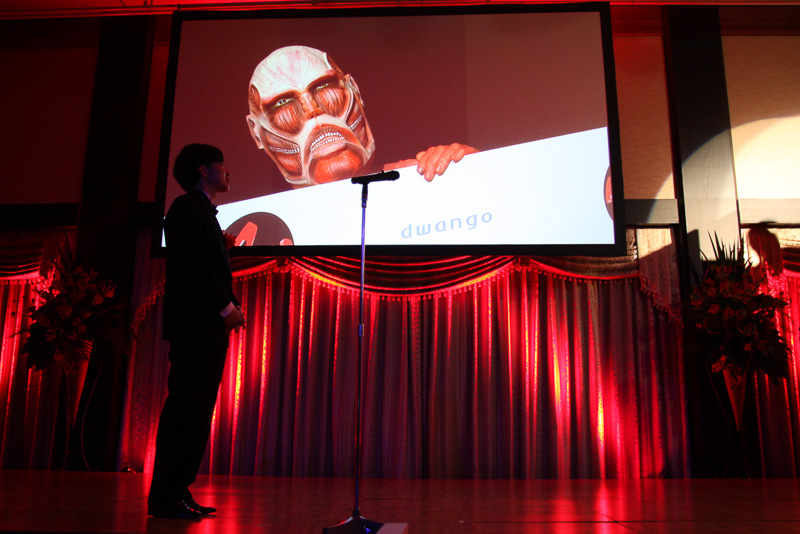 表彰シーンでは、進撃の巨人のアニメ映像が流れたあと、同作のゆるキャラ「巨人くん」が登場する演出も実施。歴史あるAMDアワードのフラッグを受け取り、この作品の幅広い展開をコミカルなアクションで表現している