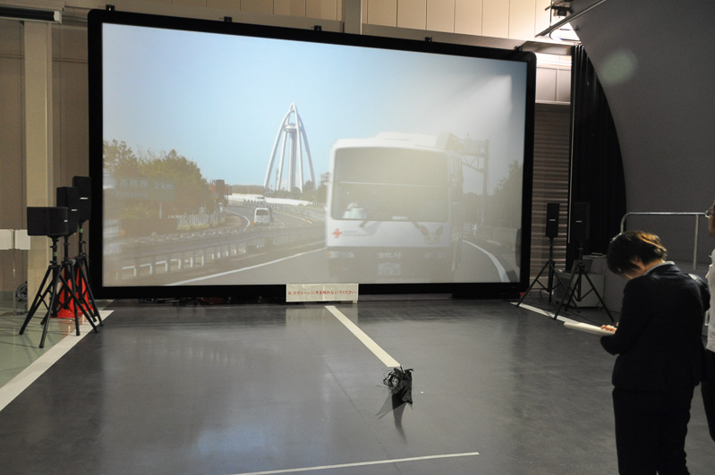 高速道路の落下物を取り除く訓練エリア。330インチのスクリーンに投影されるクルマのタイミングを見極めて飛び出す