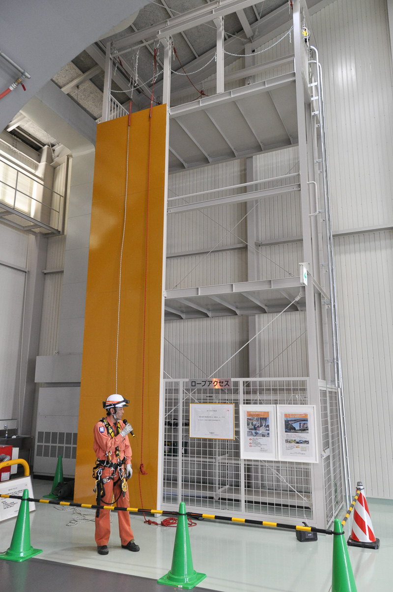ロープアクセス訓練用施設。ロープアクセスの技術を持つ点検員が増えることで足場を組むことなく各種の点検が行えるようになる。ロープで壁面を上りながら打音点検を行っていた