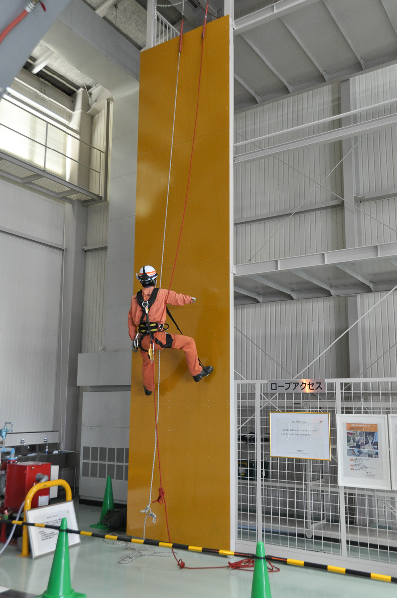 ロープアクセス訓練用施設。ロープアクセスの技術を持つ点検員が増えることで足場を組むことなく各種の点検が行えるようになる。ロープで壁面を上りながら打音点検を行っていた