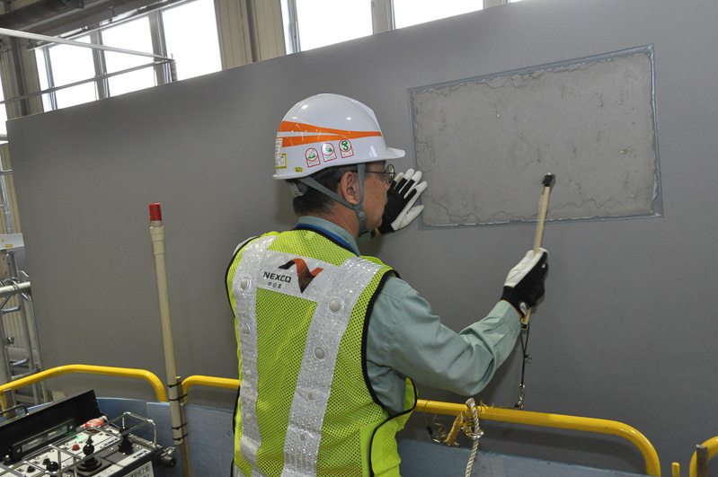 しっかり近づけて打音点検。橋梁もベニヤ板でできており、打音点検を行っている四角いエリアのみコンクリート