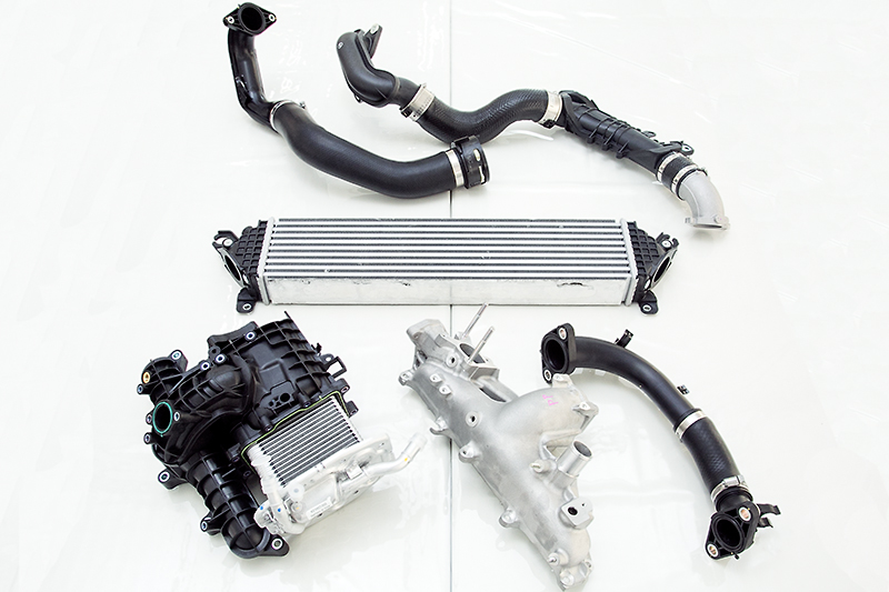 左下がSKYACTIV-D 1.5の水冷式インタークーラー、中央や右下がSKYACTIV-D 2.2の空冷式インタークーラー関連部品