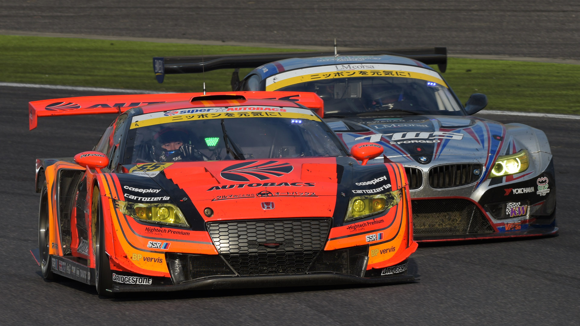 レース終盤のGT300クラスのバトル。2コーナーに向かう途中で急接近したので走って移動。夕日が車内に差し込み、バックミラーを見る目が確認できる