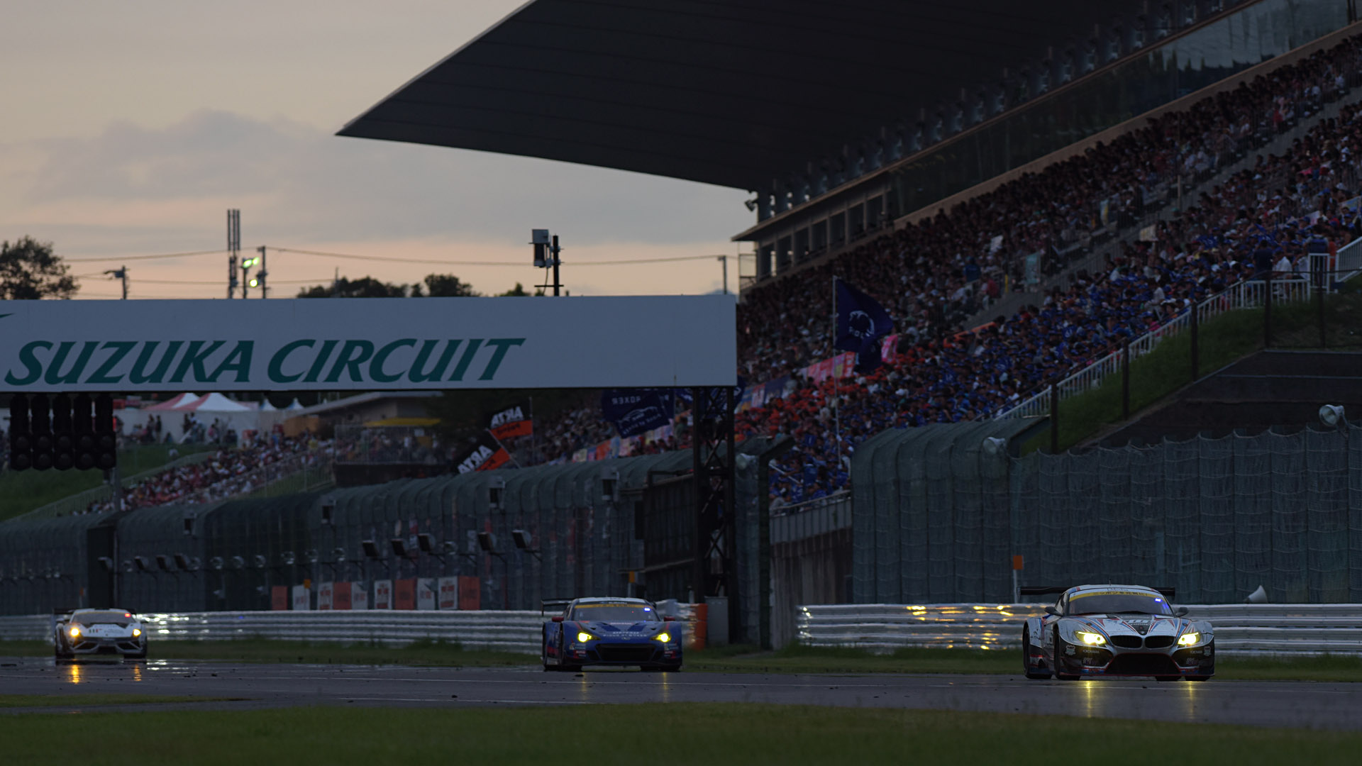 スタンドをバックにストレートを通過するマシンを撮影