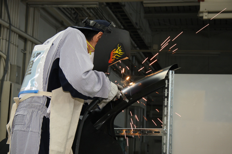 板金部門でパネル交換時の切り接ぎ個所を溶接するようす