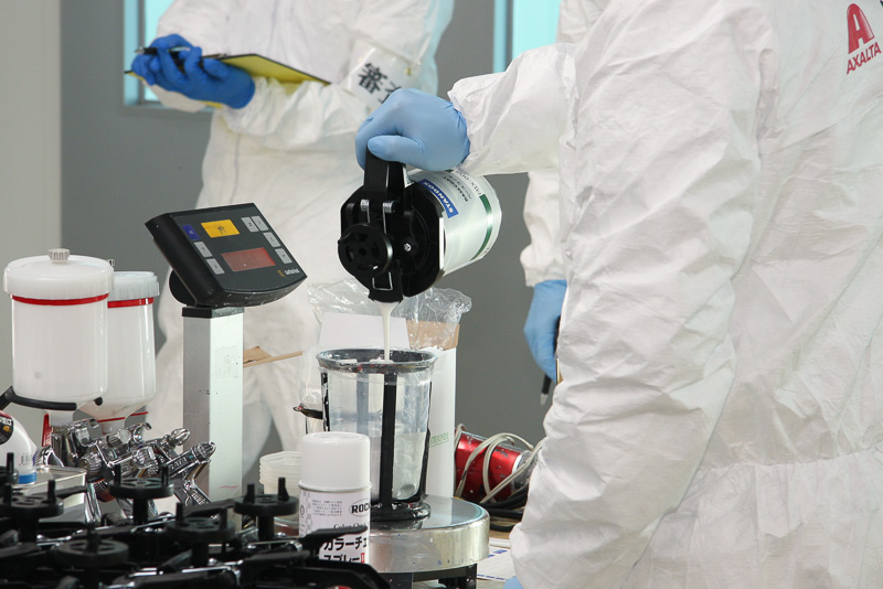 色見本パネルには各塗料の使用グラム数が記載されており、デジタルスケールで計量しながら1滴単位で微調整しつつ混合