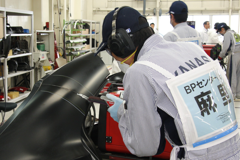 溶接時にボディーに施された塗装が影響しないよう、接続部周辺をベルトサンダーで削ってボディーパネルの地金を露出させる
