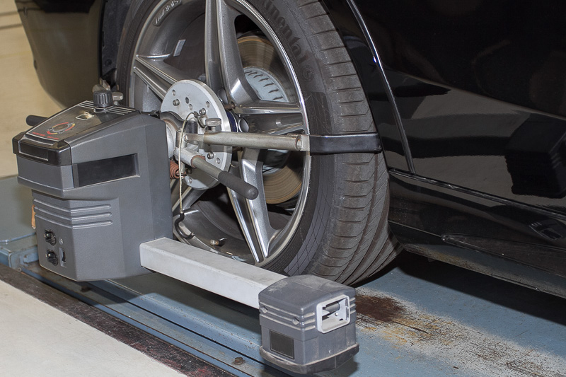 自動ブレーキの調整と同時にタイヤのアライメント調整も実施中。メルセデス・ベンツやBMWの純正ホイールにはスポーク部などに小さな穴が開いているものがあり、これは純正指定の測定器と接続するためのガイド。この穴に測定器の棒を差し込むだけで、簡単にタイヤのアライメントが計測できる仕組みになっている