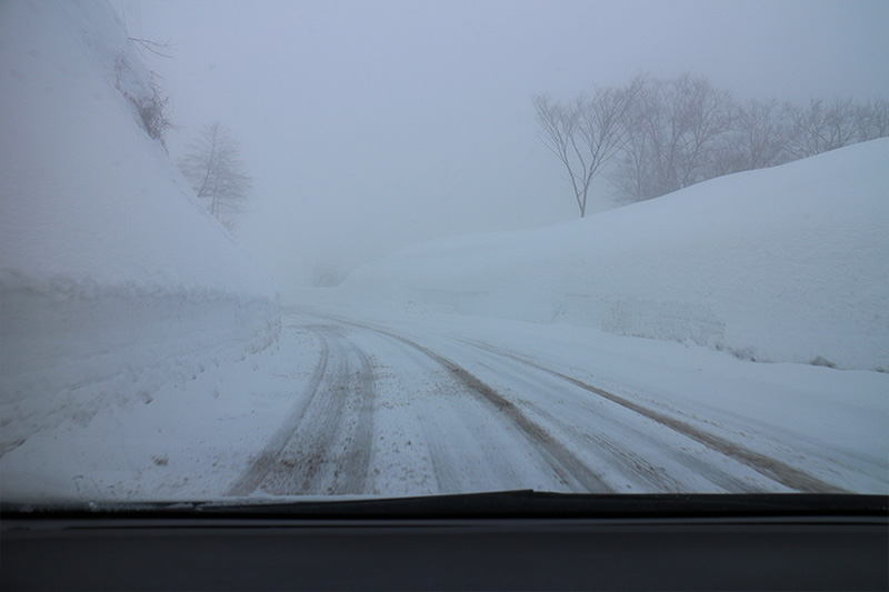 少し登ると、路面は圧雪状態に。アップダウンが続くため、道路には融雪剤や砂利が撒かれている
