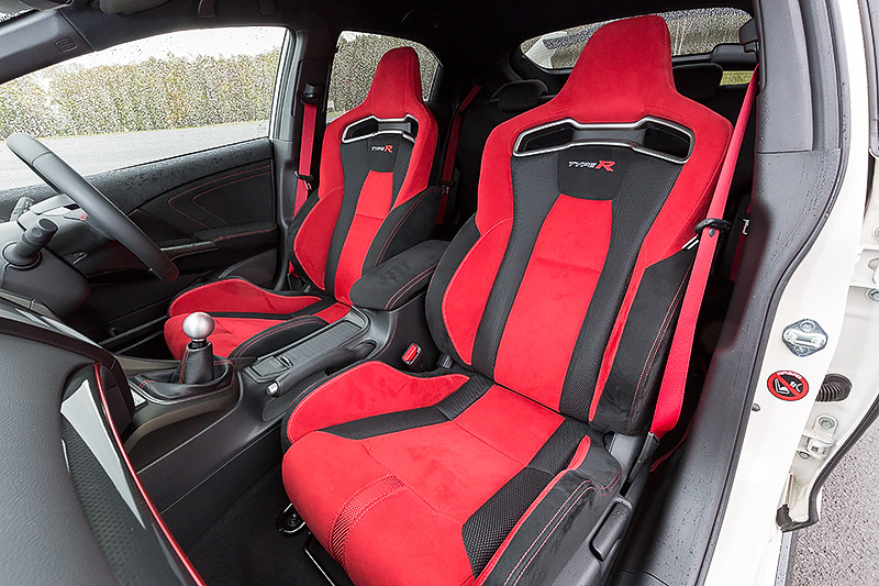 TYPE Rのロゴがあしらわれる新開発の「Honda TYPE R シート」。今回の新型シビック TYPE Rはセンタータンクレイアウトを採用しているため、フロントシート下に燃料タンクが配置されている。そのため座面クッション部のウレタンの発泡密度や硬度などが見直され、シビック TYPE R EUROと同等のクッション性能を維持しながら20％のウレタン薄型化に成功。これによりベースの欧州シビックから20mm低いヒップポイントを実現させている
