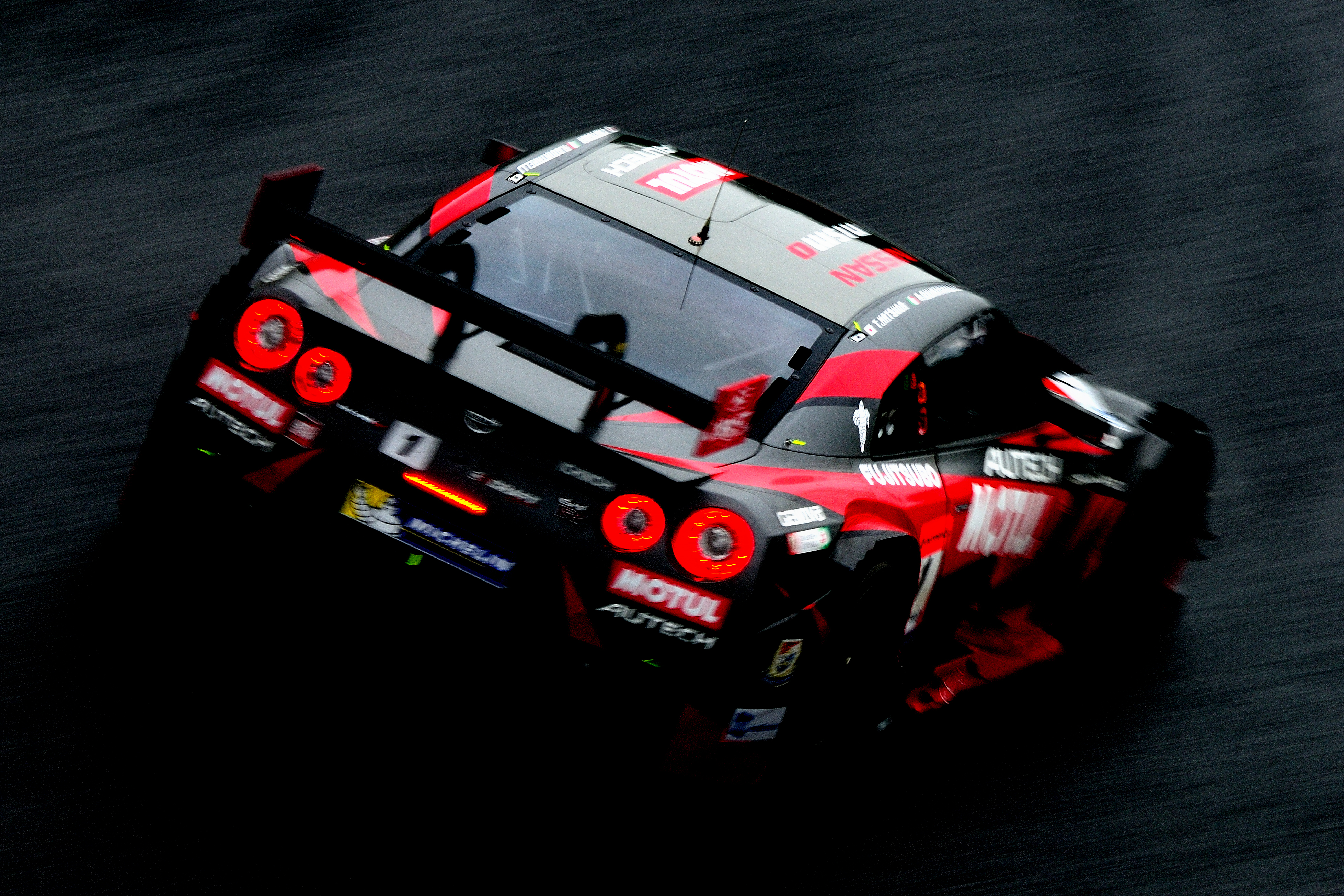 naxtさん　「赤い閃光」雨の中を走る1号車の後ろ姿をヘアピンの入り口側から。車体の赤とテールランプの赤が黒い路面に浮かび上がってとても美しく光っていました