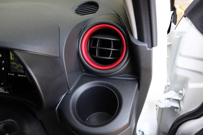 運転席の右側には固定式のドリンクホルダーもある。エアコン吹き出し口は押し込むようにして開閉させる。吹き出し口を彩るリングはブラックシートでは赤、ホワイトシートではシルバーとなる