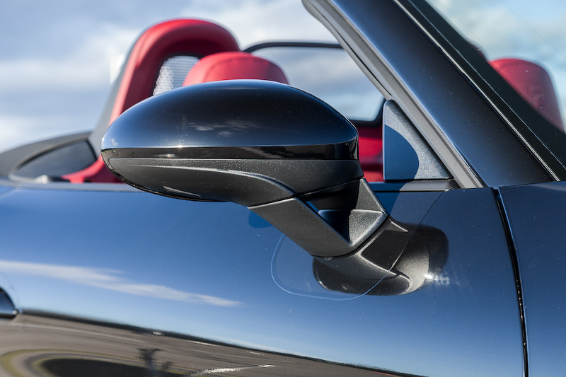 エクステリアではラゲッジコンパートメントリッドとフロントウィンドウを除くすべての部分を一新。フロント部は従来モデルよりもワイドな設計になるとともに、フロントの大型クーリングエアインテークは新ターボエンジンを搭載していることを表現。また、サイドビューでは2つのルーバーを備えた大型エアインテークパネルを、リアビューではテールランプをつなぐように配される“Porsche”のロゴが入ったアクセントストリップを採用するなどし、ダイナミックかつワイドなルックスを表現。718 ボクスター Sは19インチアルミホイールを標準装備するが、撮影車はオプションの20インチを装着している