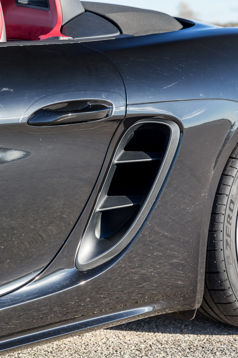 エクステリアではラゲッジコンパートメントリッドとフロントウィンドウを除くすべての部分を一新。フロント部は従来モデルよりもワイドな設計になるとともに、フロントの大型クーリングエアインテークは新ターボエンジンを搭載していることを表現。また、サイドビューでは2つのルーバーを備えた大型エアインテークパネルを、リアビューではテールランプをつなぐように配される“Porsche”のロゴが入ったアクセントストリップを採用するなどし、ダイナミックかつワイドなルックスを表現。718 ボクスター Sは19インチアルミホイールを標準装備するが、撮影車はオプションの20インチを装着している