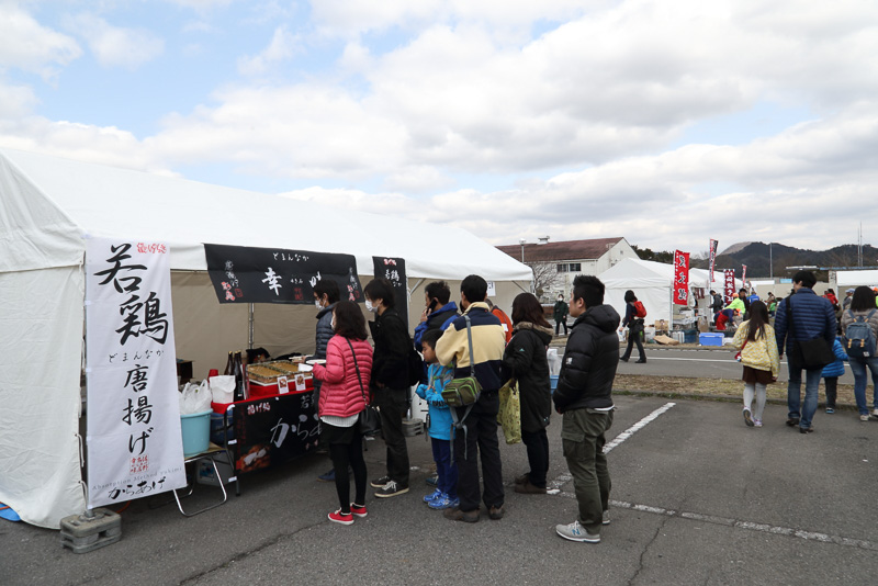 「SUBARU ACTIVE LIFE SQUARE」のコーナーや地元の飲食店の出店コーナー。会場で焼かれていた川魚は、このテストコースからほど近い旗川で獲れたイワナやニジマスだそうだ