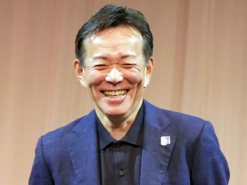 壇上で笑顔をみせる日立の徳永俊昭社長兼CEO