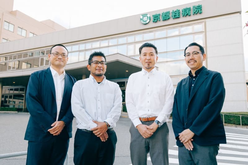 （写真左から）医療マネジメント部 情報企画室（薬剤科兼務）主任 塩飽英二氏、経営企画室 企画広報 髙松意和氏、医療マネジメント部 部長 野﨑歩氏、医療マネジメント部 情報企画室 室長 加納和哉氏