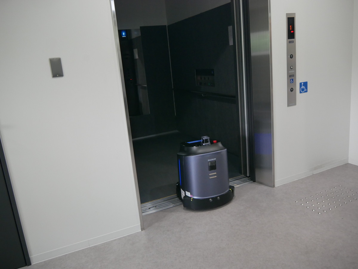 セキュリティゾーン内のエレベーターに自動で乗り込む清掃ロボット
