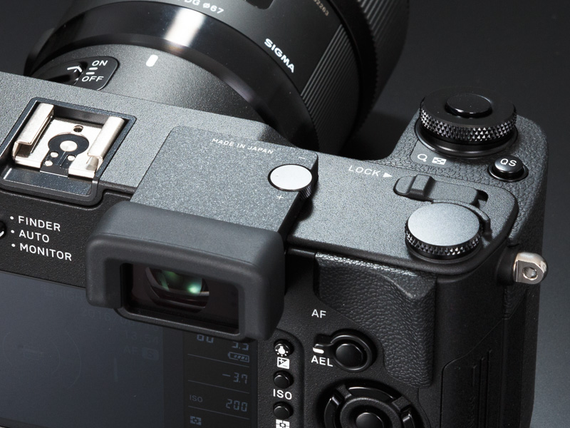 天面には、外部ストロボ用のホットシューを装備。右側には、ダイヤル操作などをロックするためのロックスイッチがある