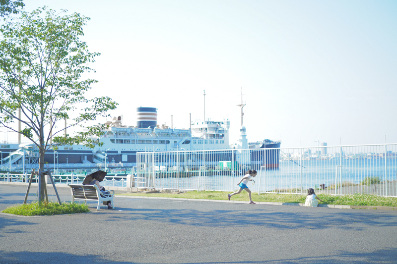 なんと穏やかな昼下がりの風景なのだ！　とうれしくなってシャッターを切った。傾きかけた光と港の風景を爽やかに、駆け出す子どものきらめきを大切にした。<br><span class="fnt-85">オリンパス PEN-F / M.ZUIKO DIGITAL 25mm F1.8 / 25mm（50mm相当) / 絞り優先AE（F1.8、1/2,000秒、+2.0EV） / ISO 200</span>