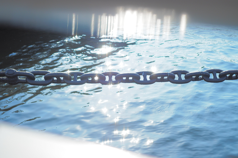 柵の隙間からのぞいたら、係留用のチェーンがキラキラとした光に彩られていて感動。柵に反射する光も美しく相まって、スナップの喜びを感じた1枚。<br><span class="fnt-85">オリンパス PEN-F / M.ZUIKO DIGITAL 25mm F1.8 / 25mm（50mm相当） / 絞り優先AE（F1.8、1/2,500秒、+1.7EV） / ISO 200</span>