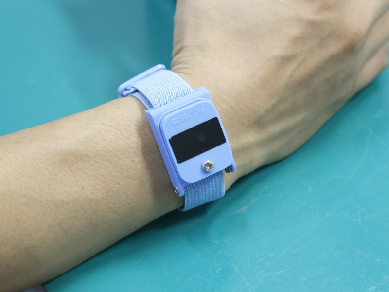 作業者は手首に静電気対策のバンドを着用。作業着も静電気対策がされたもの