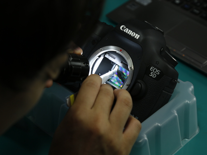 センサー清掃の手元。ピンセットにシルボン紙を巻き付けて拭き取っていく。手指のごとくピンセットを扱えるからこその芸当で、うかつにマネしてはいけないレベルだろう