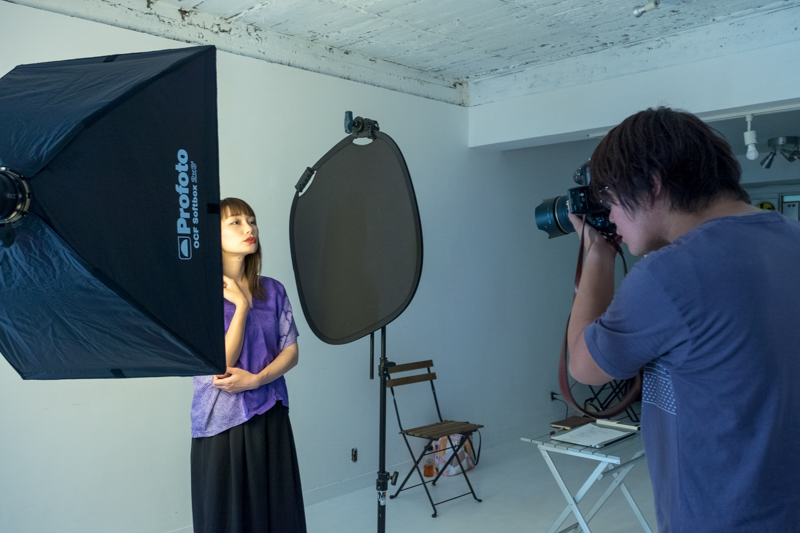 上の写真を撮った時の状況。モデルの右側にブラックのレフ板を置き、光の反射を抑えている。