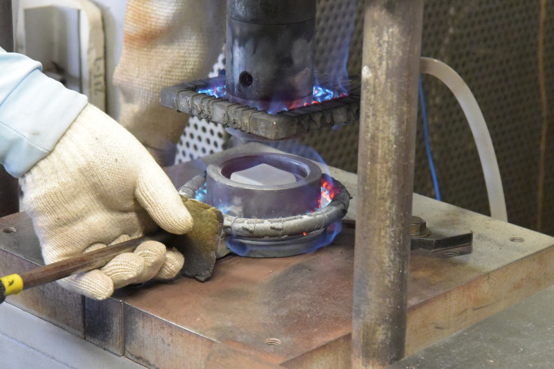 プレスの工程。軟化したガラスを金型で挟んで成形する