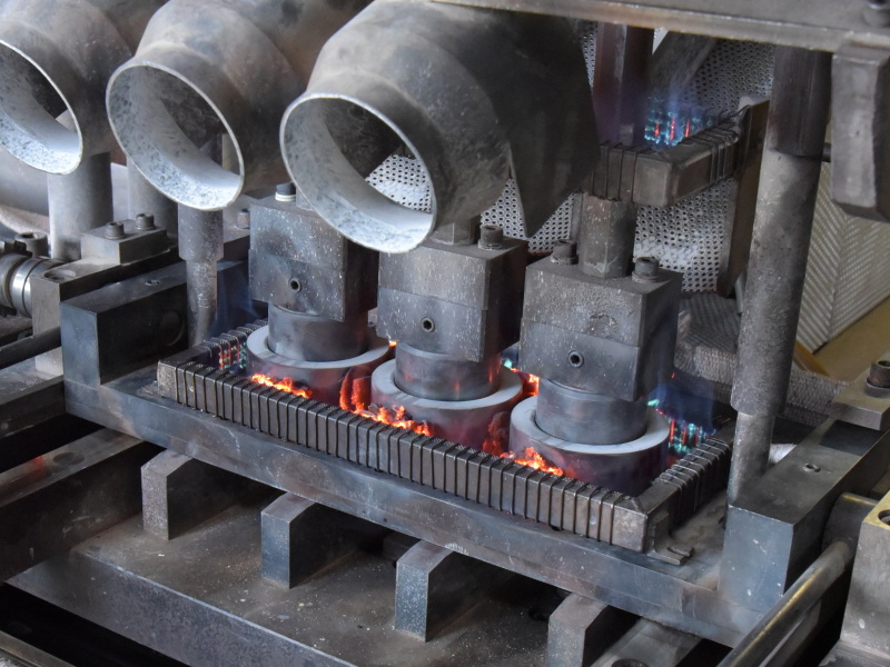 人間の背丈よりも大きい自動プレス機。大きな筐体を左右に動かしながら、代わる代わるプレス品を作り出していく