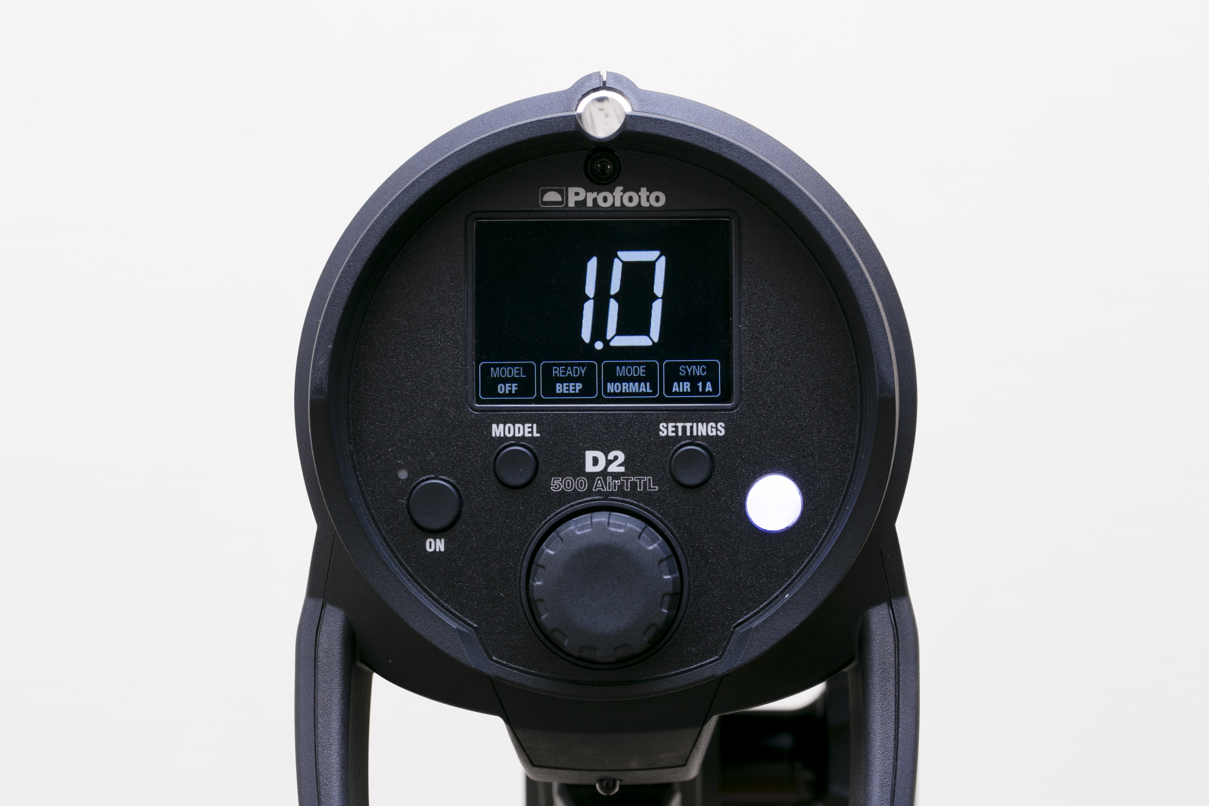 D2 500 AirTTLの背面。中央下がダイヤルボタン。その上に4つ操作ボタンが付く。左から電源ボタン、モデリングライトのON／OFFを行うMODELボタン、SETTINGSボタン、そして右端の白いボタンがテスト発光を行う際に使用するテストボタン