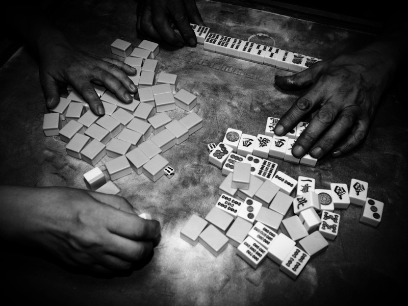 我が家ではここ数カ月間、狂ったようにファミリー麻雀に勤しんでいる。白くモヤっとしているのは牌がベタベタしないように天花粉をふったせいだ。<br><span class="fnt-85">オリンパス PEN-F / M.ZUIKO DIGITAL 17mm F1.8 / 17mm（34mm相当） /  マニュアル露出（F4、1/60秒） / ISO 400</span>