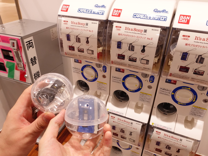 展示の最後には、カプセルトイ（1回500円）の販売コーナー。筆者は初代ウォークマンを、同行の広報担当者はモニターヘッドホンMDR-CD900（現行品のSTではないのがミソ）を引き当てた。中身は定期的に変わるそうだ