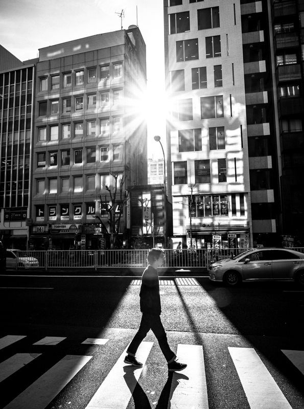 EVFを使い、ビル間から伸びる強烈な日差しと、横断歩道を渡る人を狙った。大型で高精細なEVFと全点クロス測距による高速AFで、イメージしていた瞬間を逃さず切り取れた。<span class="fnt-85">オリンパス OM-D E-M1 Mark Ⅱ / M.ZUIKO DIGITAL ED 12-40mm F2.8 PRO / 12mm（24mm相当）/ マニュアル露出（F9、1/320秒）/ ISO 200</span>