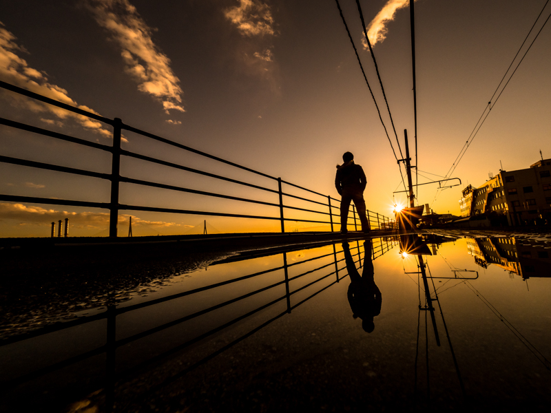 水たまりを使いシンメトリー構図で自分撮り。カメラの底面が水たまりに触れる状況だったが、十分な防滴性能を備えた組み合わせだったため、安心して撮影することができた。<span class="fnt-85">オリンパス OM-D E-M1 Mark Ⅱ / M.ZUIKO DIGITAL ED 7-14mm F2.8 PRO / 7mm（14mm相当）/ マニュアル露出（F11、1/640秒）/ ISO 200</span>