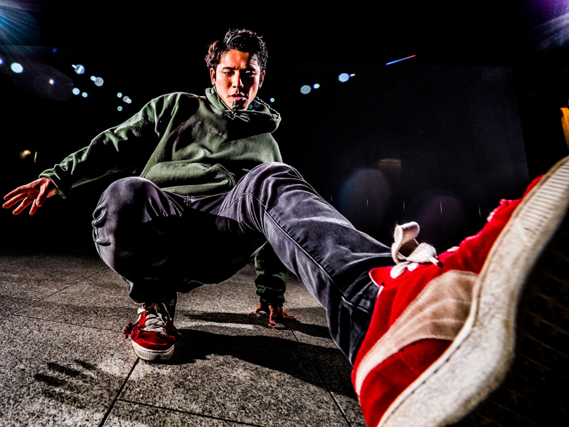 撮影時はダンサーとの間合いが重要。手になじむ形状のグリップは長時間持っていても疲れにくいため、軽いフットワークでダンサーとの距離を詰められる。<br><span class="fnt-85">オリンパス OM-D E-M1 Mark Ⅱ / M.ZUIKO DIGITAL ED 7-14mm F2.8 PRO / 7mm（14mm相当） / マニュアル露出（F5、1/125秒） / ISO 400 / ダンサー:たいしん</span>