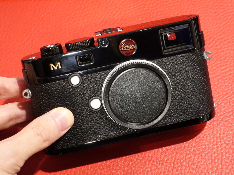 ライカMブラックアンバーの試作品を手にする坂崎さん。漆つながりで、ジョン・レノンのためにオノ・ヨーコがヤマハにオーダーした"ドラゴン"と呼ばれる漆塗りギターについて、漆とギターの適正湿度の違いから製造に苦労した話、その納品から半年でジョン・レノン自身が撃たれて亡くなった話を回想。