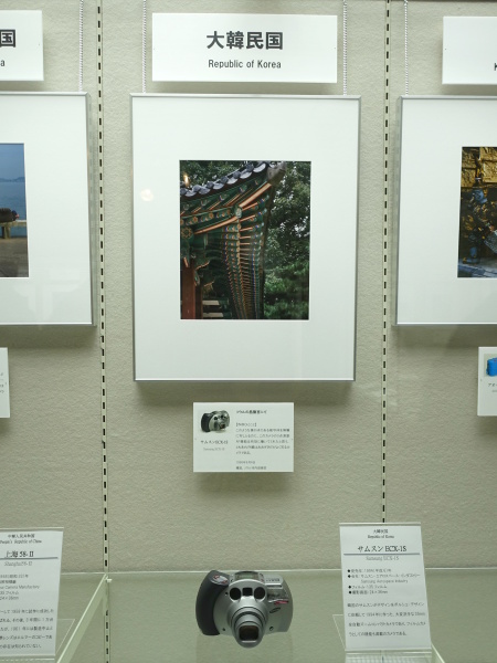 大韓民国の「サムスンECX-1S」（サムスン・エアロスペース・インダストリー、1994年）。3点測距AFが有効に働いたという作品とともに展示されていた。独特のデザインはポルシェデザインによるもの。