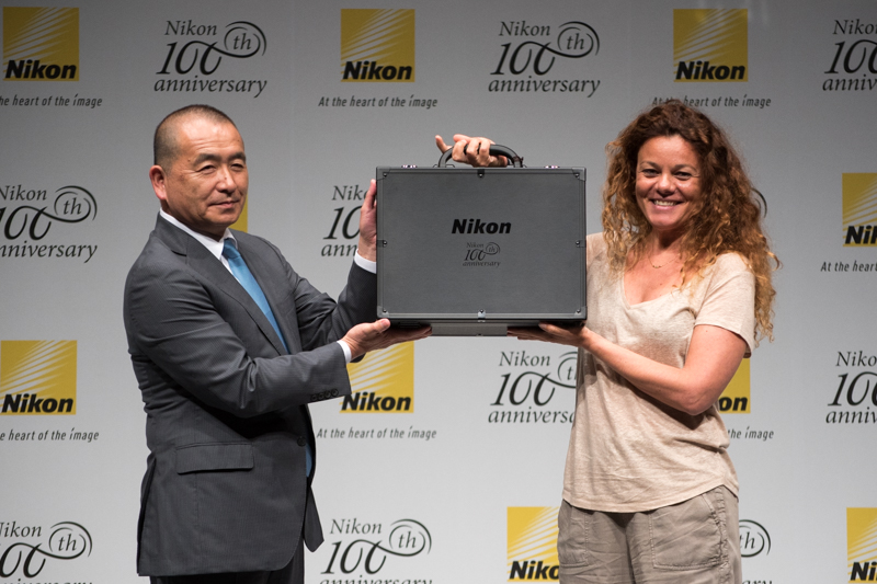ニコン創立100周年記念グランプリを射止めたAnnamaria Bruniさん（右）。賞品はD5 100周年記念モデル。左は株式会社ニコン常務執行役員・映像事業部長の御給伸好氏。