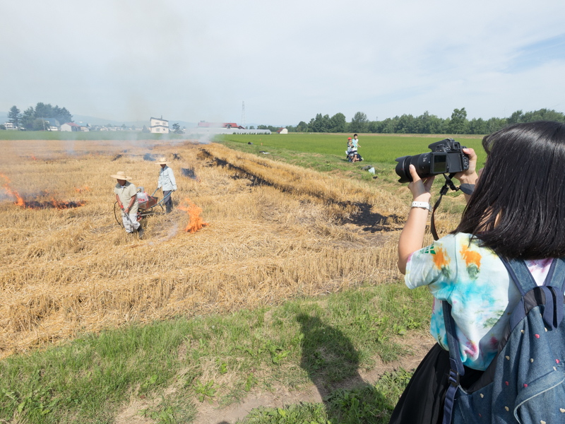 野焼きの様子を撮影する選手
