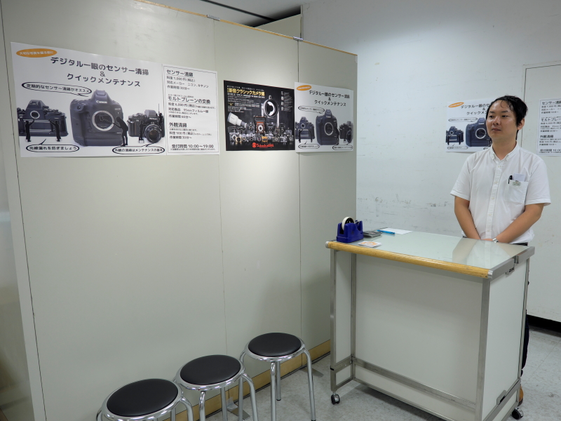 クラシックカメラ博の目玉の1つ、イメージセンサーの清掃コーナー。この展示即売会に出店し、カメラのメンテナンスでよく知られているユー・シー・エスが担当する。対象はキヤノンおよびニコンのデジタル一眼レフカメラで、1台税込1,000円。そのほか、このコーナーではモルトプレーン交換（税込6,000円）と外観清掃（税込500円）も行っている。