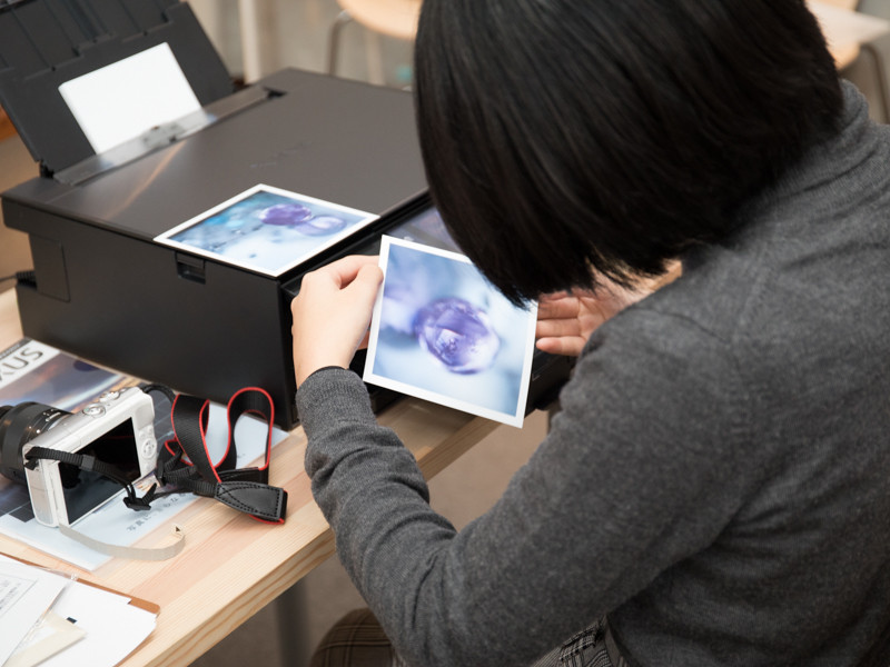 プリントのできばえを確認する参加者。